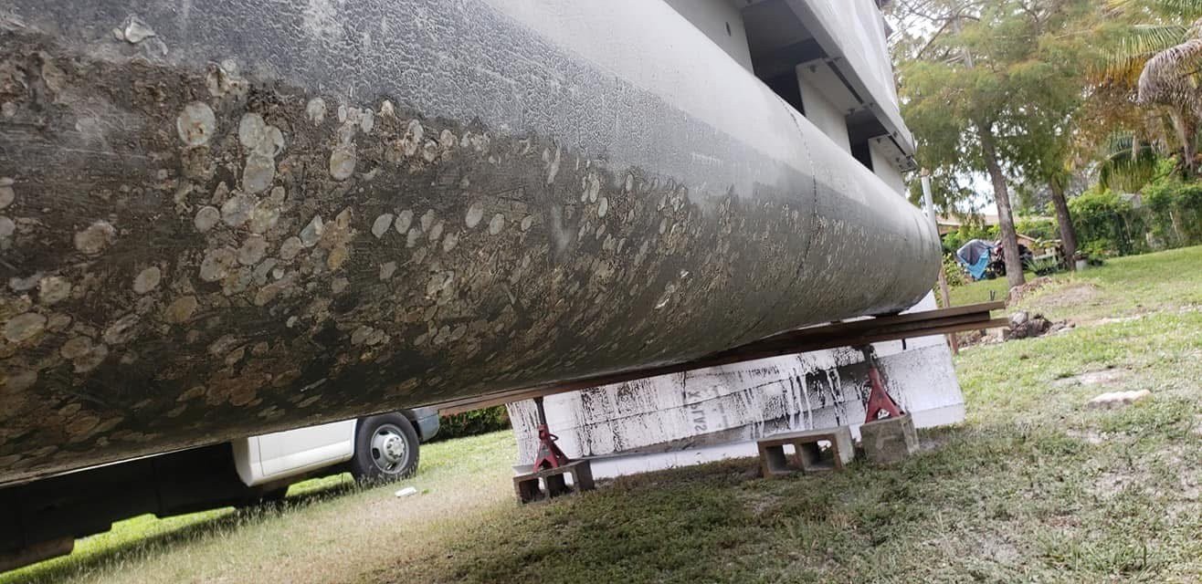 Boat hull bottom heavily fouled with barnacle growth before blasting